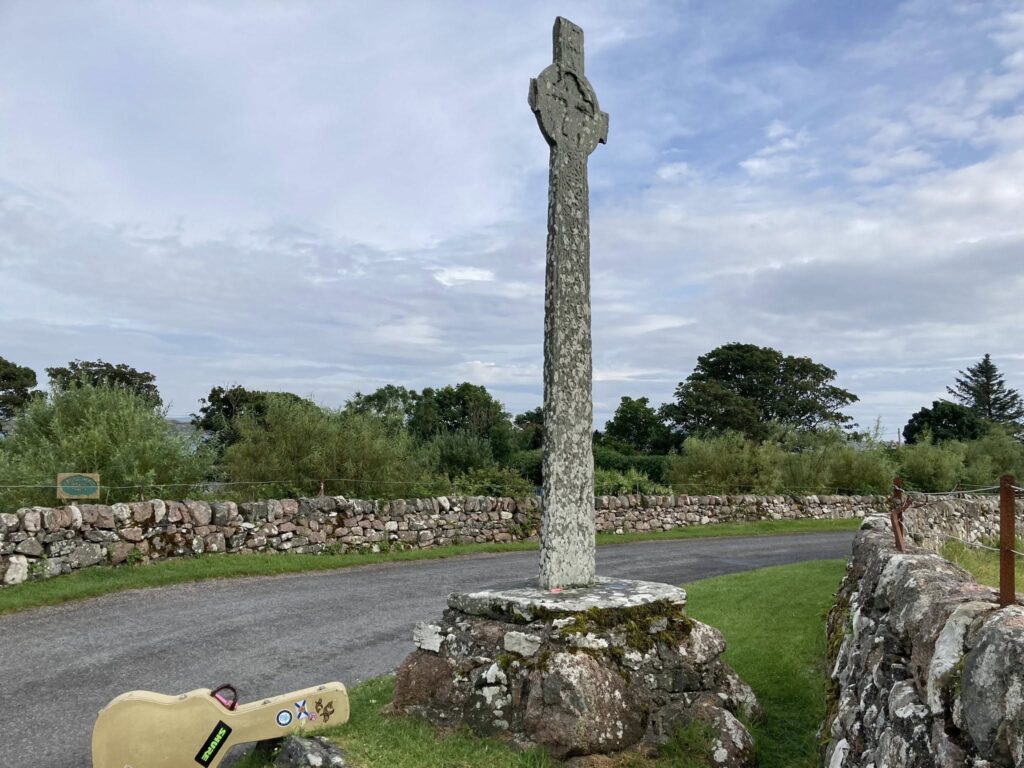 Connie MacLeod's guitar (a 1985 Martin) in case, resting beside a Celtic Cross on the isle of Iona